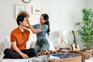 Asian young beautiful couple preparing clothes and packing suitcase. 