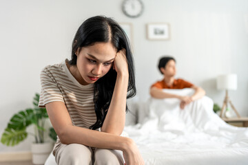 Asian stressed woman and aggressive man screaming at each other in house.