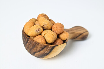 Photo of egg nuts in the little wooden spoon isolated on white background. Clipping path. Close up. 