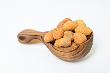 Photo of egg nuts in the little wooden spoon isolated on white background. Clipping path. Close up. 