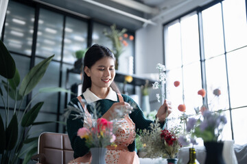 Happy asian female florist Startup small business successful SME in flowers shop 