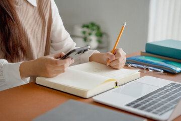 Asian girl student doing exam hand holding pencil writing answer in university classroom education high school or university student taking notes while preparing for exam