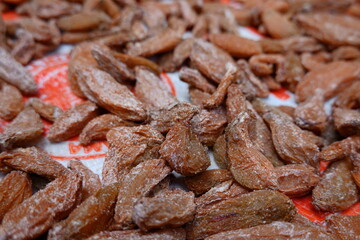 assortment of dried bilimbi fruits displayed on a traditional woven tray