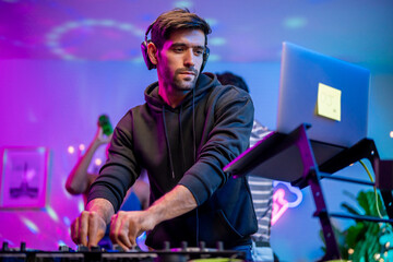 Caucasian young man artist DJ mixing and scratching music mixer controller. 