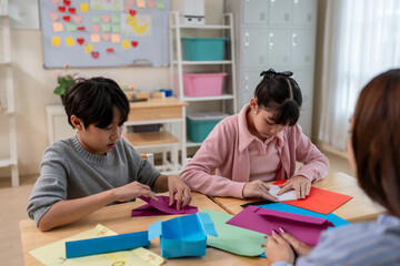Asian teacher educating students in an art class at elementary school. 