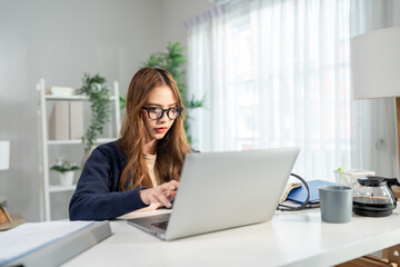 Fototapeta premium Asian attractive woman freelancer using laptop device working in house. 