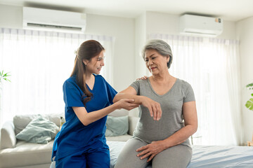 Obraz premium Elderly Asian woman receive physical therapy with support of caregiver. 