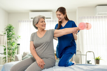 Obraz premium Asian senior mature woman doing physiotherapist with support from nurse. 