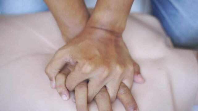 basic CPR training resuscitation emergency breathing Performing CPR on a mannequin to practice lifesaving techniques.