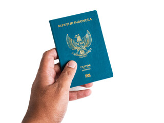 Isolated view of a hand holding a green Indonesian passport book on a white background.