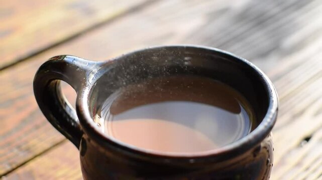 Cafe de Olla in Dark Clay Mug with Steam Rising on Weathered Wooden Table Warm Lighting Delicious Mexican Coffee