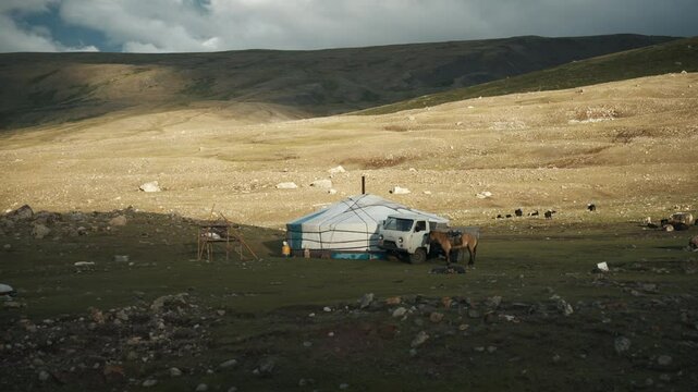 Wide-angle static shot of Khoron Lake in Mongolia on a sunny morning, capturing daily life with people, animals and gers