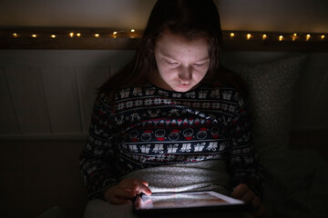 Girl using smart phone while lying on bed in bedroom