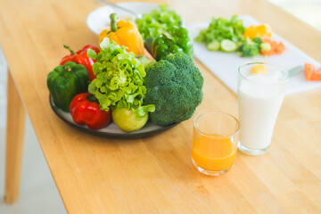 A fresh assortment of colorful vegetables, orange juice,milk highlights a balanced diet.The measuring tape symbolizes healthy eating,weight control,nutrition-focused lifestyle choices for wellness