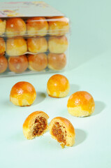 a clear jar pineapple cakes, one sliced and three on the ground