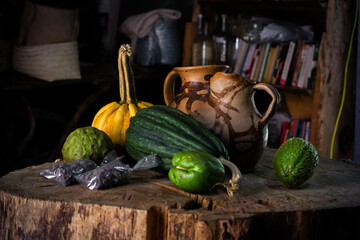 Bodegón de vegetales y jarras de barro sobre un tronco de madera rustico con verduras locales de...