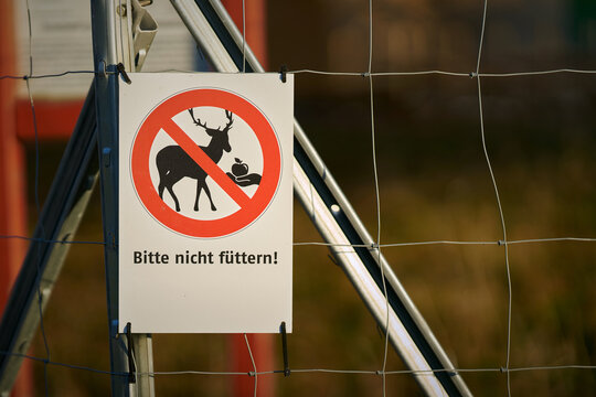 Schild am Zaun eines Wildgeheges mit der deutschen Aufschrift Bitte nicht f&uuml;ttern