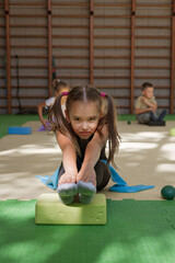 Training of children in the gym. Gymnastics, circus, fitness for girls.