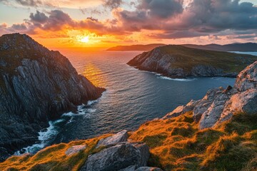 Dramatic sunset over rugged coastline. Rocky cliffs meet the ocean, painted with fiery hues