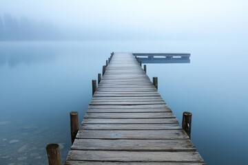 Fototapeta premium Tranquil wooden dock extends into a misty lake