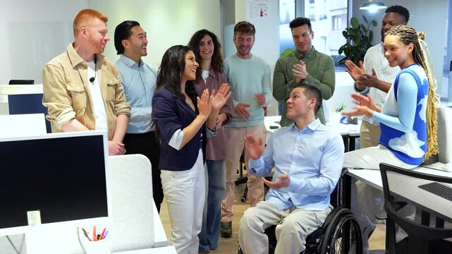 Diverse business team applauding a colleague in a wheelchair