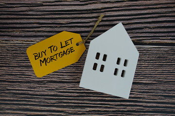 Buy To Let Mortgage text on price tag with white house model flat lay on wooden background