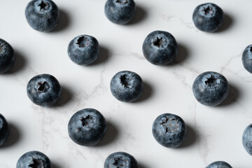 Blueberries Arranged on White Marble Background
