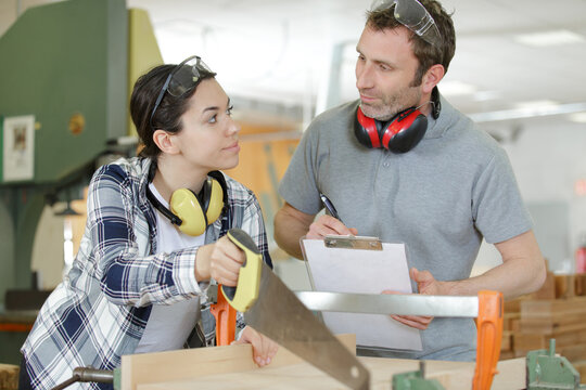 carpenter man and woman working in workshop as a team