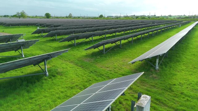 Aerial drone solar power station renewables gas coal fossil fuels Electricity generation Agri voltaic trainline railway closeup rural fields England UK