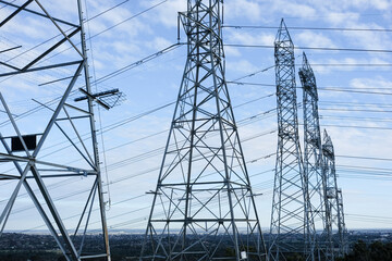 A row of power line towers stretching across the landscape