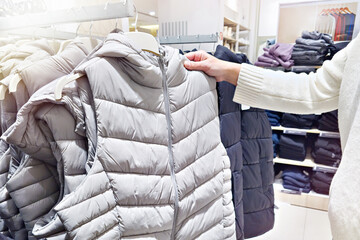 Warm vest and customer in clothing store