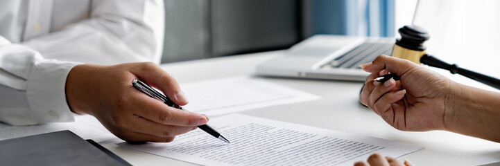 Lawyer with lawsuit meeting with client discussing with contract agreement at law firm