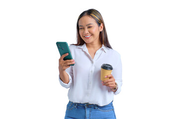 Portrait of smiling young Asian woman looking at mobile phone and drinking coffee isolated on...