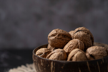 Walnuts filling a coconut shell bowl resting on a table