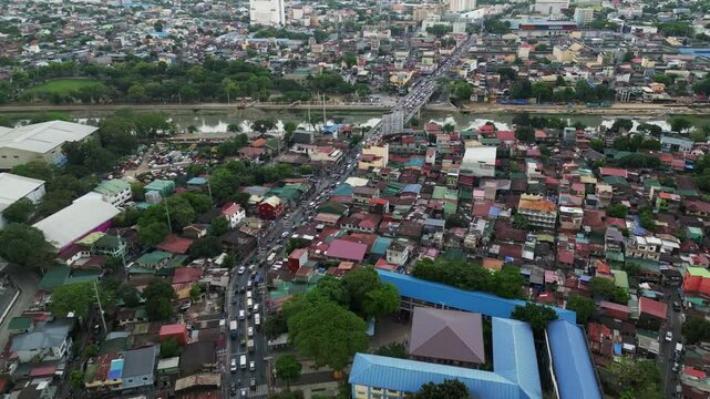 Dense Marikina neighborhood from above with houses, rooftops, and narrow connecting streets, high angle aerial overview of rush hour traffic