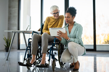 The image includes a person using a wheelchair, depicting inclusivity and teamwork in modern office