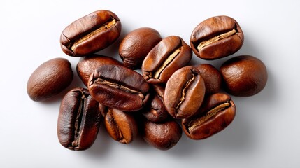 Obraz premium Pile of coffee beans with the beans being brown in color. The beans are spread out on a white surface