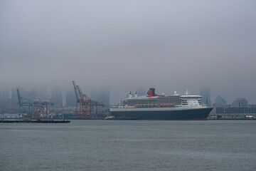 Luxury ocean liner cruiseship cruise ship Queen Mary docked at terminal in Brooklyn on grey rainy...