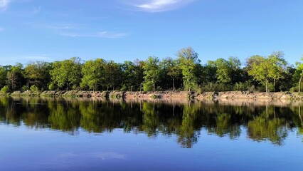 river and forest. Beautiful landscape the river bank is surrounded by forest. Steep sandy beach. Lake in the forest