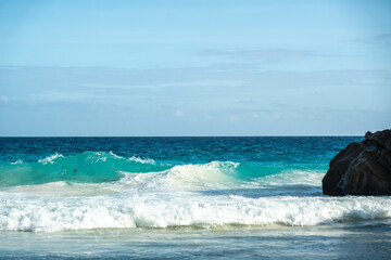 Huge dangerous waves crashing on the beautiful Seychelles beach, with powerful ocean surf