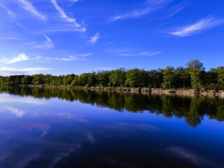 river and forest. Beautiful landscape the river bank is surrounded by forest. Steep sandy beach. Lake in the forest. reflection of the forest in river water. Evening