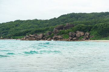 A typical Seychelles coast features granite boulders, dense tropical vegetation