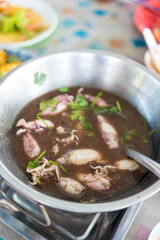 A bowl of squid in black soup. Thai seafood