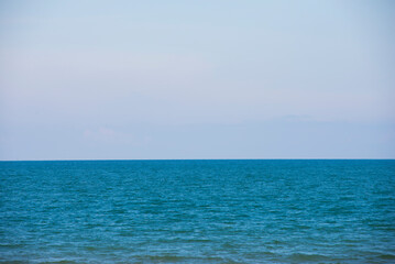 Blue sea and sky background. Sea waves on the seashore.