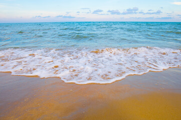 Soft wave of the sea on the sandy beach. Summer background.