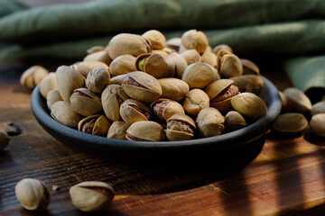 Roasted pistachios nuts in bowl. Top view.