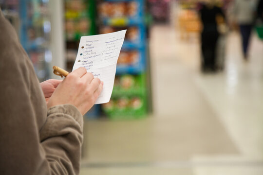 Woman holding shopping list in grocery store