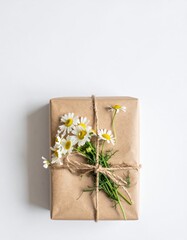 A beautifully wrapped gift adorned with vibrant daisies and delicate flowers, featuring a colorful ribbon that adds a cheerful touch to the presentation.