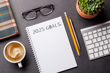 Elegant leather desk setup with laptop, coffee, stationery, and a notepad labeled 2025 Goals