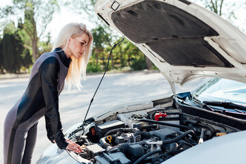 Female car mechanic repairing car engine